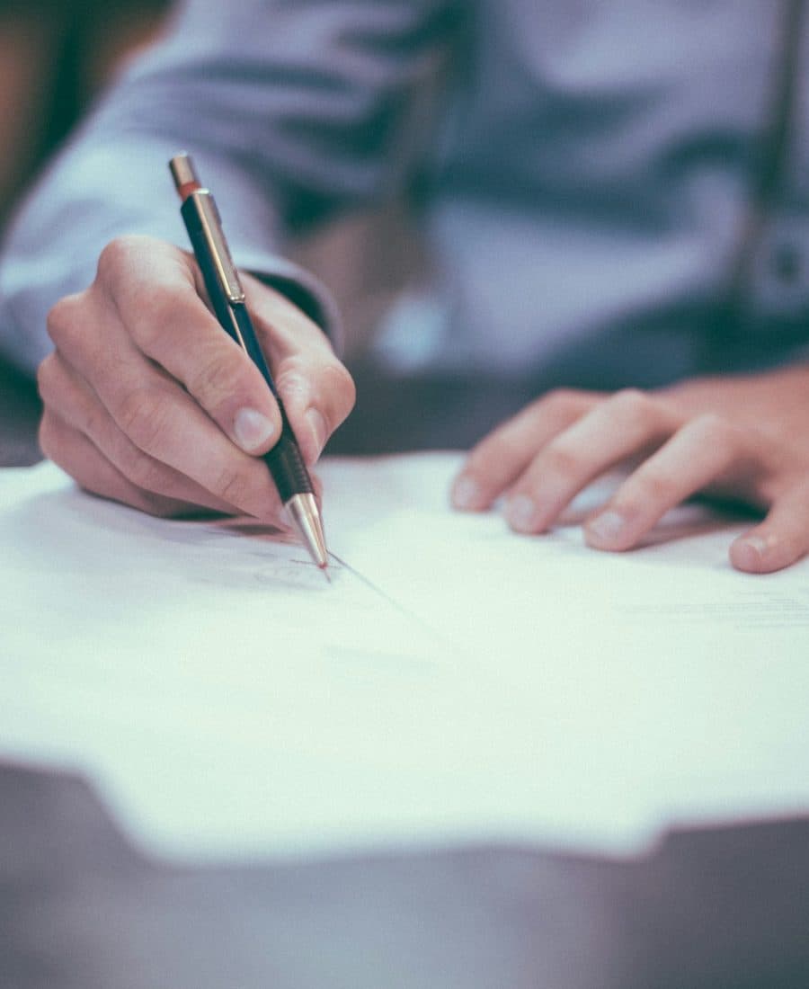 Formation commercial B2B — devenir commercial B2B Commercial signant un contrat de vente, stylo à la main, sur un bureau